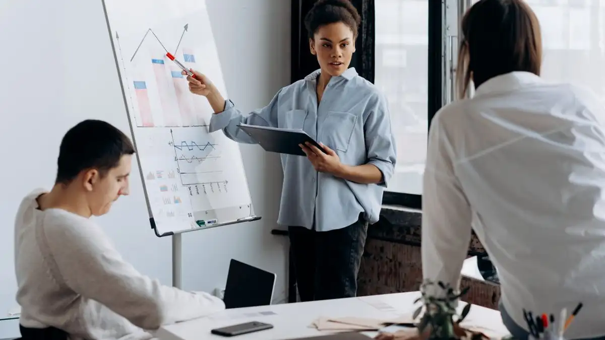 Tim bisnis mendiskusikan strategi dengan presentasi di lingkungan kantor modern.