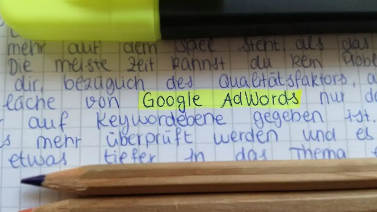 Dekat pensil berwarna di catatan tulisan tangan dengan Google AdWords disorot.