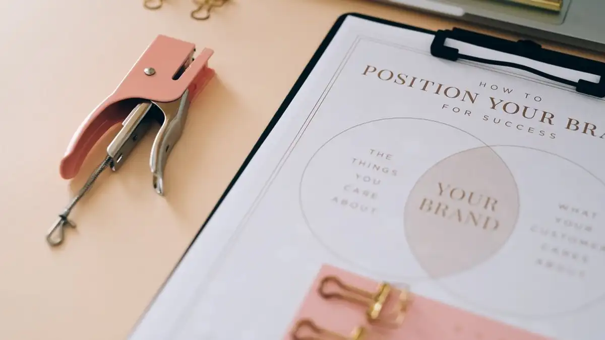 Stapler pink dan dokumen branding di meja yang menampilkan pengaturan kantor yang stylish.