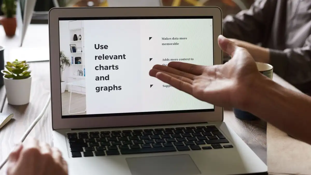 Gambar dekat pertemuan bisnis dengan tangan yang bergerak menuju layar laptop.