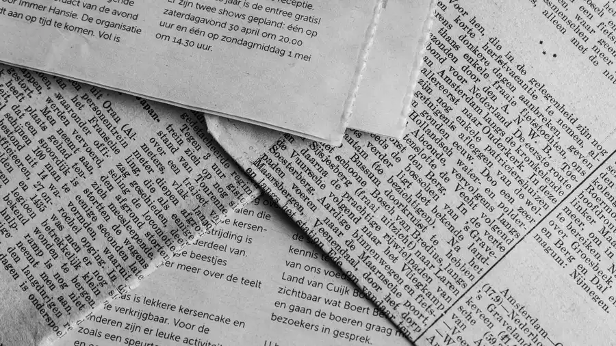 Tangkapan dekat hitam putih halaman surat kabar dengan teks dalam bahasa Belanda.