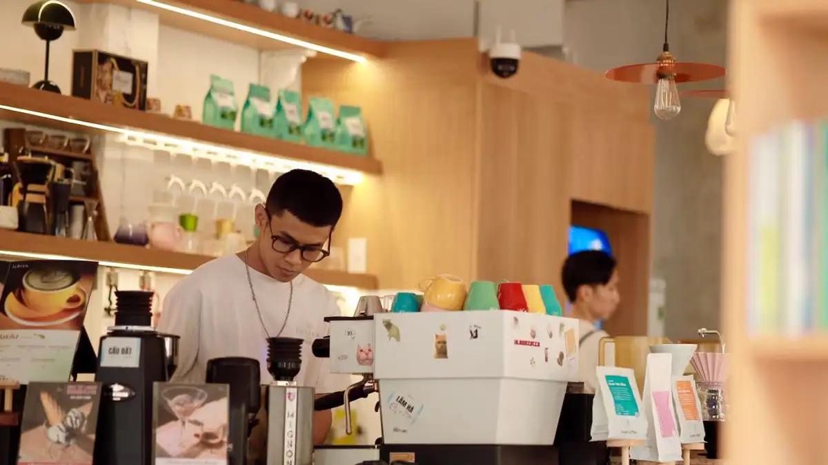 Barista bekerja dengan giat di lingkungan kafe yang nyaman dan modern.