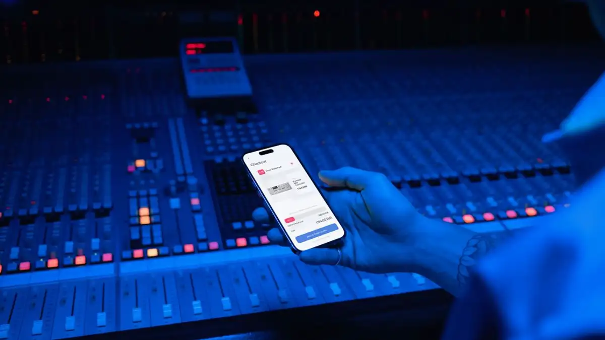 Sebuah ponsel pintar menampilkan pembayaran digital dalam suasana studio musik modern.