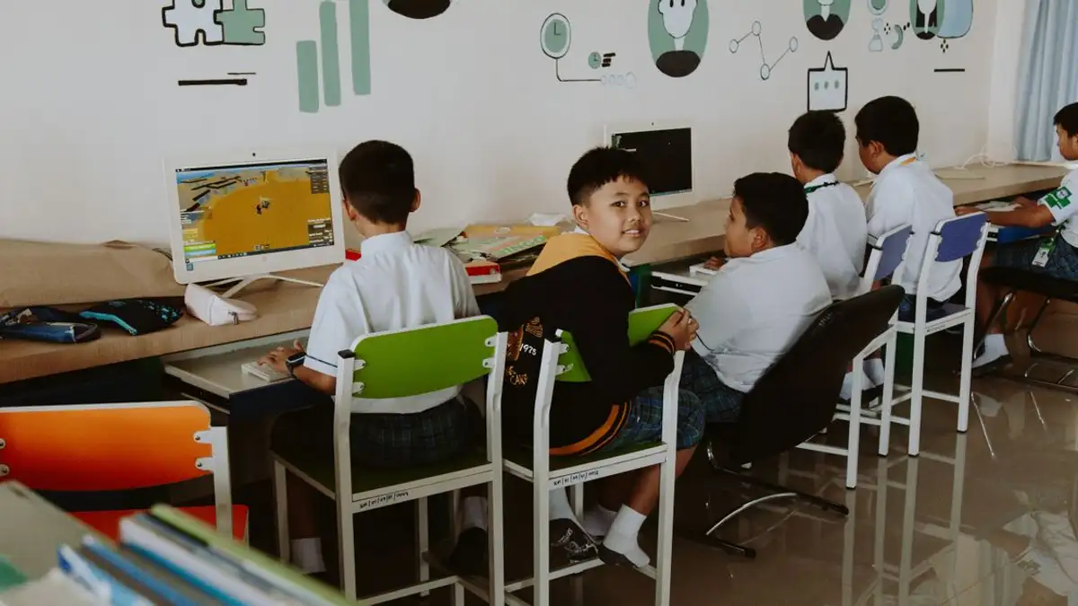 Siswa sekolah dasar belajar di lingkungan kelas modern yang didorong oleh teknologi.