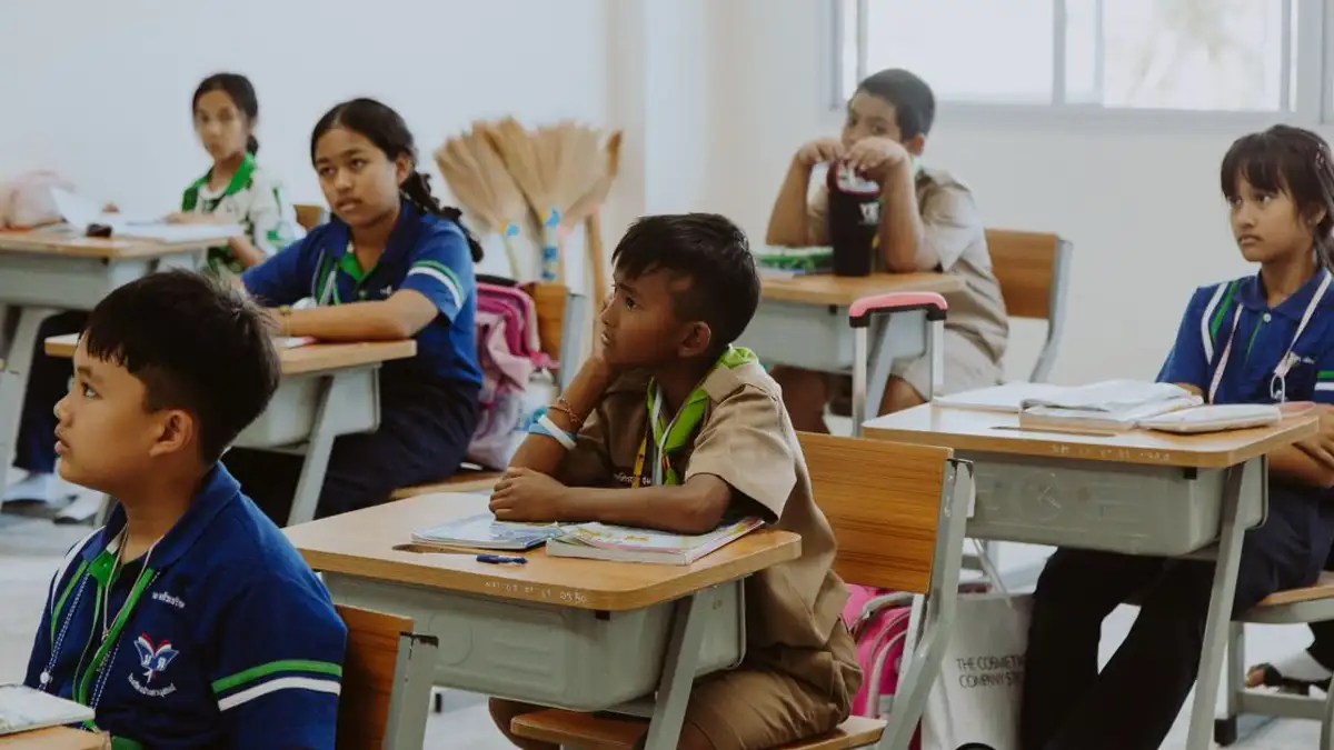 Anak-anak yang mendengarkan dengan penuh perhatian di lingkungan kelas, fokus pada pembelajaran dan pendidikan.